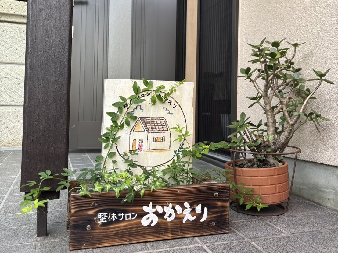 整体サロン おかえりの入口(木の看板と手描きのボード)